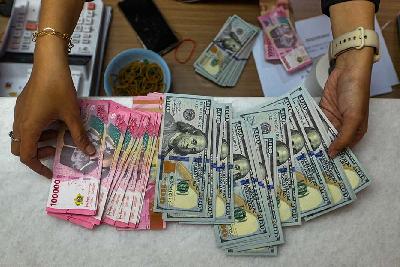 Karyawan menghitung pecahan 100 dolar Amerika di penukaran valuta asing di Jakarta, 4 Oktober 2023. Tempo/Tony Hartawan