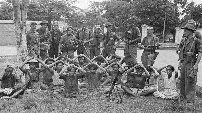 Tawanan perang Indonesia, dengan tangan di atas kepala, di bawah pengawalan sekelompok tentara Belanda, di Solo, Desember 1948. Dienst voor Legercontacten Indonesië/Nationaal Archief