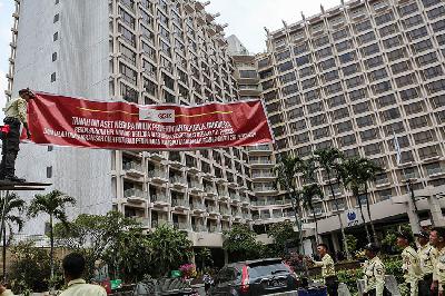 Petugas dari Pusat Pengelolaan Kompleks Gelora Bung Karno (PPK GBK) memasang spanduk pemberitahuan tanah aset negara di depan Hotel Sultan, Kompleks GBK, Jakarta, 4 Oktober 2023. ANTARA/Asprilla Dwi Adha