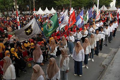 Sejumlah remaja perempuan membawa bendera partai peserta pemilu saat pembukaan Kirab Pemilu 2024 di Makassar, Sulawesi Selatan, 20 Juli 2023.  ANTARA/Arnas Padda