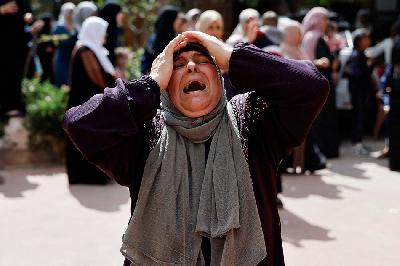 Warga Palestina menangis saat pemakaman empat warga Palestina yang tewas dalam bentrokan dengan pemukim Israel, dekat Nablus di Tepi Barat yang diduduki Israel 12 Oktober 2023. REUTERS/Ammar Awad