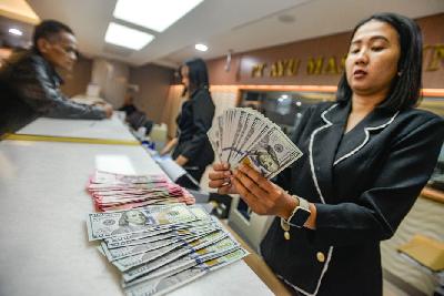 Karyawan tengah menghitung uang pecahan 100 dolar Amerika di penukaran valuta asing di Jakarta, 4 Okotber 2023. Tempo/Tony Hartawan