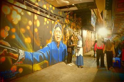 Suasana pengunjung di depan lukisan mendiang penyanyi campur sari legendaris Didi Kempot di koridor jalan Gatot Subroto Solo, Jawa Tengah, 27 Oktober 2023. TEMPO/SEPTHIA RYANTHIE