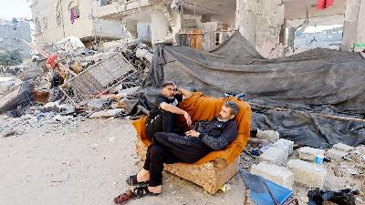 Warga Palestina beristirahat di sofa dekat  rumah yang rusak akibat serangan Israel, di Khan Younis, Jalur Gaza, Palestina, 7 November 2023. Reuters/Mohammed Salem