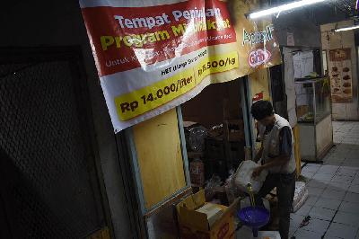 Pedagang menuang minyak yang akan dijual dengan harga Rp 14.000 per liter di Pasar Kosambi, Bandung, Jawa Barat, 2022. TEMPO/Prima Mulia