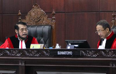 Ketua Mahkamah Konstitusi Anwar Usman (kiri) dan Hakim Konstitusi Suhartoyo saat sidang putusan atas gugatan Undang-Undang Nomor 7 tahun 2017 tentang Pemilu terkait usia minimal capres-cawapres menjadi 35 tahun di MK, Jakarta, 16 Oktober 2023. TEMPO/Subekti