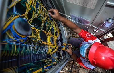 Petugas melakukan perawatan jaringan internet di Perumahan Pondok Karya, Jakarta. Tempo/Tony Hartawan