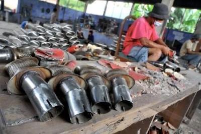 Seorang pekerja menyelasikan proses pembuatan knalpot secara manual di sentra industri knalpot di Desa Pesayangan, Purbalingga, Jawa Tengah. ANTARA/Idhad Zakaria