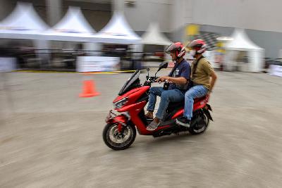 Pengunjung mencoba sepeda motor listrik pada pameran Indonesia Motorcycle Show (IMOS+) 2023 di Convention Exhibition (ICE) BSD, Kabupaten Tangerang, 25 Oktober 2023. Tempo/Tony Hartawan