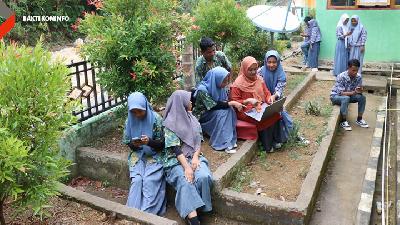 Pelajar dan Kepala Sekolah SMA Negeri 1 Wawonii Utara Rosidah Asnai saat menggunakan akses internet dari BAKTI Aksi Kominfo di Kabupaten Konawe Kepulauan, Sulawesi Tenggara. (TEMPO/Lourentius EP)