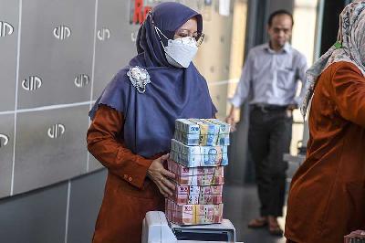 Petugas membawa uang pecahan rupiah di gerai penukaran mata uang asing VIP (Valuta Inti Prima) Money Changer, Jakarta, 20 November 2023. ANTARA/Muhammad Adimaja