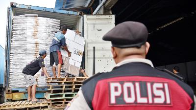 Polisi mengawasi pekerja saat mengangkut kotak suara di gudang KPU Kota Medan, Sumatera Utara, 21 November 2023. Antara/Fransisco Carolio