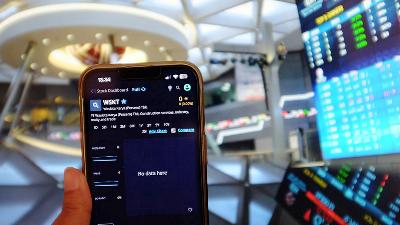 Waskita Karya’s shares trade, which has been suspended by the Indonesian Stock Exchange, is monitored on a mobile phone. 
TEMPO/Tony Hartawan
