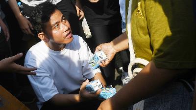 Vice-presidential candidate Gibran Rakabuming Raka distributes packaged milk to residents during the car-free day in Jalan MH Thamrin, Jakarta, December 3. 
ANTARA/Aditya Pradana Putra

