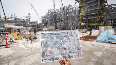 Pekerja menunjukan denah kawasan pembangunan proyek Smelter Freeport di Kawasan Ekonomi Khusus Java Integrated and Industrial Port Estate (KEK JIIPE), Gresik, Jawa Timur, 9 November 2023. Antara/Rizal Hanafi