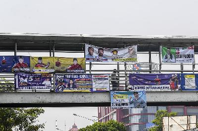 Warga melintas di Jembatan Penyeberangan Orang (JPO) yang tertutup Alat Peraga Kampanye (APK) di kawasan Salemba, Jakarta, 7 Desember 2023. ANTARA/Galih Pradipta
