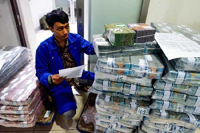 Pegawai tengah menyiapkan uang tunai di cash pooling Bank Mandiri, Jalan Gatot Subroto, Jakarta, 11 Desember 2023. Tempo/Tony Hartawan