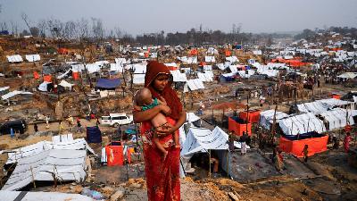 Seorang pengungsi wanita etnis Rohingya dan anaknya melihat kamp pengungsian mereka pasca terjadi kebakaran di kamp Cox's Bazar, Banglades, 24 Maret 2021. Reuters/Mohammad Ponir Hossain