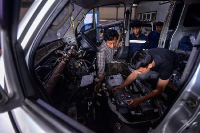 Mekanik menyelesaikan konversi mobil biasa ke mobil listrik di bengkel kerja Spora EV di Lengkong, Tangerang Selatan, Banten, 3 Februari 2023. TEMPO/Tony Hartawan