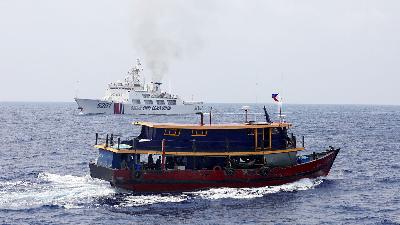 Sebuah kapal Filipina berlayar di dekat kapal Penjaga Pantai Tiongkok di Laut Cina Selatan, 4 Oktober 2023/REUTERS/Adrian Portugal/File Foto