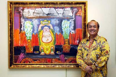 Pelukis Hardi dengan latar lukisan karyanya dalam Pameran lukisan Tunggal XIX "Gelora Imlek-Bhinneka Tunggal Ika" di Jakarta, 2009. Dok. TEMPO/ Arnold Simanjuntak