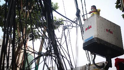 Bina Marga official organizing disorderly and dangling utility cables in the Pasar Mampang Prapatan area, Jakarta, September 5, 2022. 
TEMPO/Hilman Fathurrahman W
