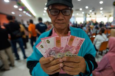 Warga menunjukkan uang Bantuaan Langsung Tunai (BLT) El Nino di Kantor Pos Oceania, Jakarta, 29 Desember 2023. TEMPO/Tony Hartawan