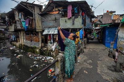 Warga beraktivitas di pemukiman padat penduduk di pinggir kali di  Kebon Kacang, Jakarta, 30 Mei 2023. TEMPO/Tony Hartawan