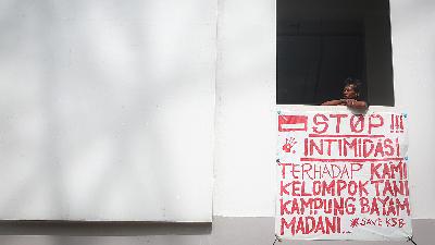A resident takes a break at low-rise apartment Kampung Susun Bayam (KSB), North Jakarta, January 22, 2023. The KSB residents are those who have been displaced from their old homes to make way for the construction of Jakarta International Stadium (JIS). The poster says “Stop Intimidation against Us, Bayam Village’s Farming Group”
TEMPO/Hilman Fathurrahman W
