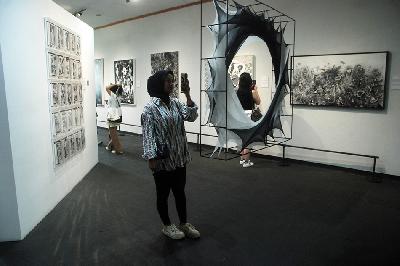 Pengunjung memotret salah satu karya dalam pameran "1st Grey Annual Award" di Galeri Grey, Bandung, Jawa Barat, 11 Februari 2024. TEMPO/Prima Mulia