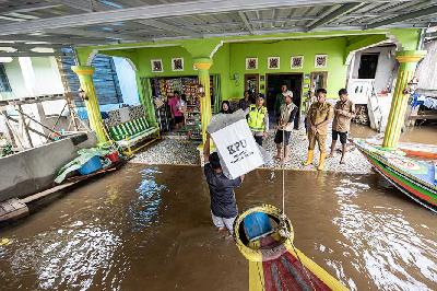 Petugas memanggul kotak suara berisi logistik Pemilu 2024 menuju tempat pemungutan suara di perairan sungai Musi Pulo Kerto, Palembang, Sumatera Selatan, 13 Februari 2024. ANTARA/Nova Wahyudi
