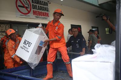 Petugas Penanganan Prasarana dan Sarana Umum (PPSU) mengangkat kotak suara untuk didistribusikan ke kantor RW maupun ke TPS-TPS di Jakarta, 13 Februari 2024. TEMPO / Hilman Fathurrahman W
