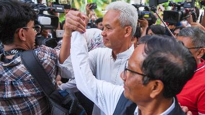 Presidential candidate Ganjar Pranowo (white shirt) and his running mate Mahfud MD hold hands after watching the quick count of the 2024 presidential election at their campaign headquarters in Teuku Umar, Jakarta, February 14.  
ANTARA/M Risyal Hidayat
