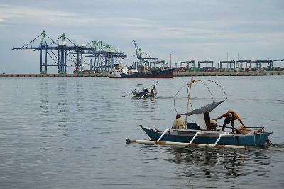 Perahu nelayan melintas di perairan Paotere dengan latar belakang proyek pembangunan Makassar New Port (MNP) di Makassar, Sulawesi Selatan, 4 Januari 2024. ANTARA/Arnas Padda