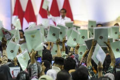 Warga menunjukkan sertifikat tanah yang telah diserahkan pemerintah saat Presiden Joko Widodo memberikan sambutan pada penyerahan sertifikat tanah di Bandung, Jawa Barat, 3 Februari 2024. ANTARA/Hafidz Mubarak A
