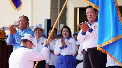 Perdana Menteri Kamboja Hun Sen pemimpin People Party's setelah menyerahkan bendera partainya kepada putranya Jenderal Hun Manet di Phnom Penh, 1 Juli 2023. Reuters/Cindy Liu