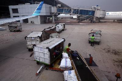 Petugas memasukan bagasi penumpang di Bandara Soekarno-Hatta, Cengkareng, Tangerang, Banten. TEMPO/ Nita Dian