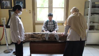 Pengunjung Museum Kesehatan Jiwa dr. Radjiman Wediodiningrat mencoba alat pasung untuk pasien gangguan jiwa. di Lawang, Kabupaten Malang, Jawa Timur. Tempo/Eko Widianto