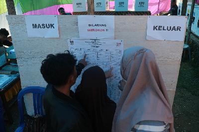 Warga melihat poster calon legislatif sebelum menyalurkan hak pilihnya di TPS 02 Wawombalata, Kendari, Sulawesi Tenggara, Kamis 22 Februari 2024. ANTARA/Andry Denisah