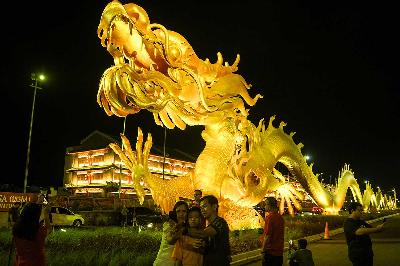 Warga berfoto dengan latar belakang patung naga di kawasan Pantai Indah Kapuk (PIK) 2, Kosambi, Kabupaten Tangerang, Banten, 10 Februari 2024. ANTARA/Sulthony Hasanuddin