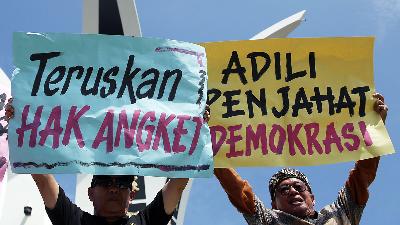 Warga mengangkat poster mendukung Hak Angket terkait kecurangan Pemilu 2024, di bundaran Simpang Lima, Banda Aceh, Aceh, 20 Maret 2024. Antara/Irwansyah Putra