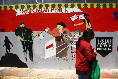 Warga berjalan di depan mural bertema Pemilu serentak Pilpres, Pileg dan Pilkada 2024 di Jalan Perjuangan Raya, Jakarta, 28 September 2023. ANTARA/Reno Esnir