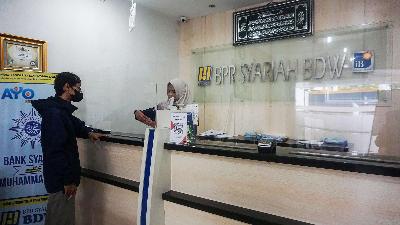 A customer conducting transactions with the teller at Bangun Drajat Warga Sharia People’s Financing Bank (BPRS BDW), owned by Muhammadiyah, June 12.
TEMPO/Shinta Maharani
