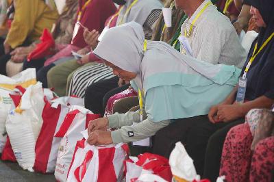 Warga menerima bantuan pangan beras cadangan pangan pemerintah kepada Keluarga Penerima Manfaat (KPM) oleh Presiden Joko Widodo di Gudang Bulog, Cibitung, Jawa Barat, 16 Februari 2024. TEMPO/Subekti