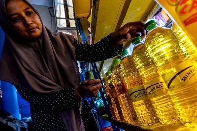 Karyawan toko tengah menata minyak merek Minyakita kemasan botol di etalase toko kawasan Kebayoran Lama, Jakarta, 21 Juni 2024. TEMPO/Tony Hartawan