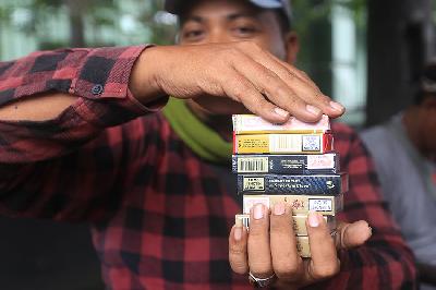 Pedagang menunjukan rokok dagangannya di Terminal Kampung Rambutan, Jakarta. TEMPO/Subekti

