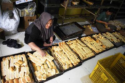 Pekerja pabrik Mekarsari 99 mengemas roti manis dengan kemasan sederhana di sentra pabrik roti rumahan Babakan Rahayu, Kelurahan Kopo, Bandung, Jawa Barat, 17 Juli 2024. TEMPO/Prima Mulia