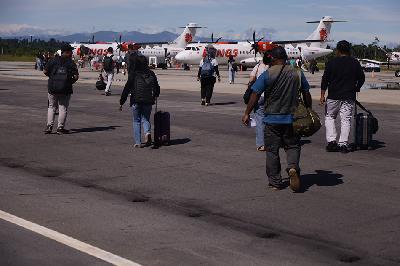 Penumpang berjalan menuju pesawat di Bandara Douw Aturure Nabire di Wanggar, Kabupaten Nabire, Papua Tengah, 17 Mei 2024. TEMPO/ Nita Dian