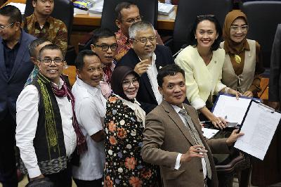 Menteri Dalam Negeri Tito Karnavian (kedua kiri), Wakil Ketua Badan Legislasi DPR RI Achmad Baidowi (ketiga kiri) dan sejumlah Anggota Badan Legislasi DPR RI berfoto bersama usai dalam rapat keputusan pembahasan RUU Pilkada di Kompleks Parlemen, Senayan, Jakarta, 21 Agustus 2024. TEMPO/M Taufan Rengganis