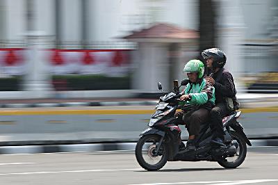 Pengemudi ojek online (ojol) melintas di kawasan Patung Kuda, Monas, Jakarta, 29 Agustus 2024. TEMPO/Subekti